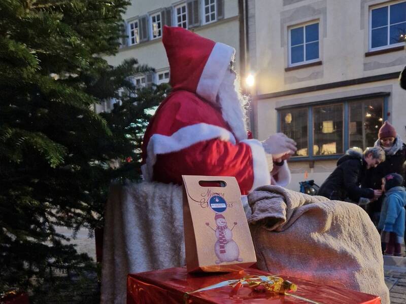 Weihnachtsmann sitzt unter dem Christbaum am Marktplatz