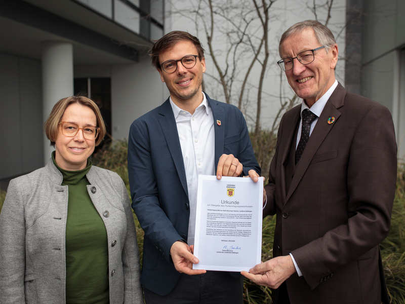 Claudia Kallning, (Leiterin Amt für Vermessung und Flurneuordnung, Landratsamt Böblingen), Landrat Roland Bernhard und Bürgermeister Christian Walter halten die Urkunde in der Hand.