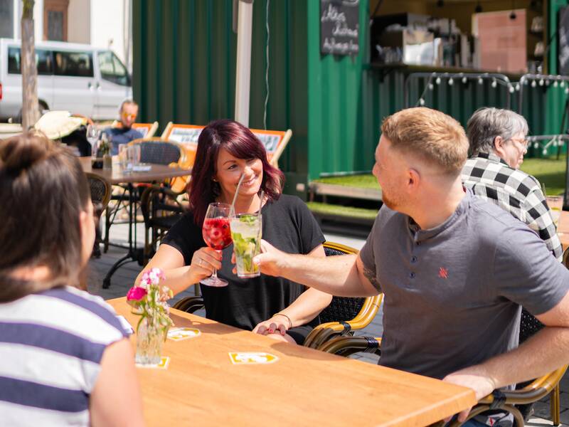 Eine Familie genießt das gastronomische Angebot auf dem Marktplatz der Stadt.