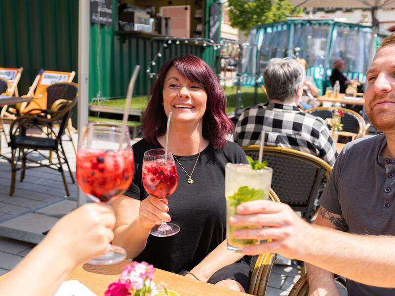 Eine Familie genießt das gastronomische Angebot auf dem Marktplatz der Stadt.