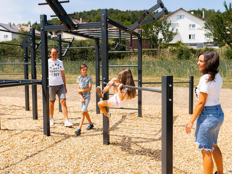 Eine Familie spielt auf einem Spielplatz.