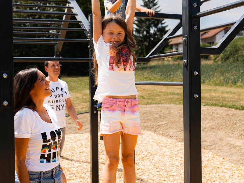 Eine Familie spielt auf einem Spielplatz.