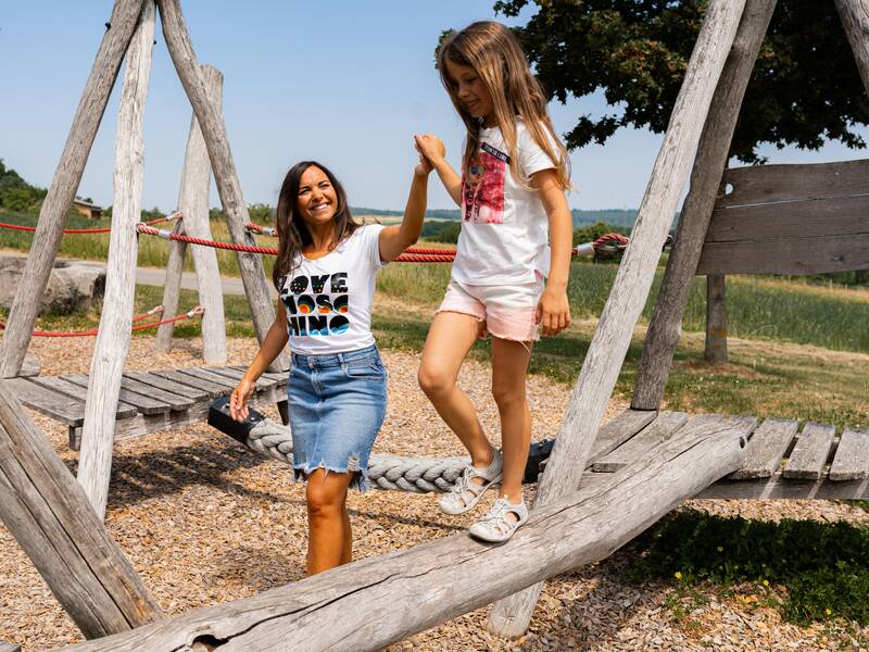 Eine Familie spielt auf einem Spielplatz.