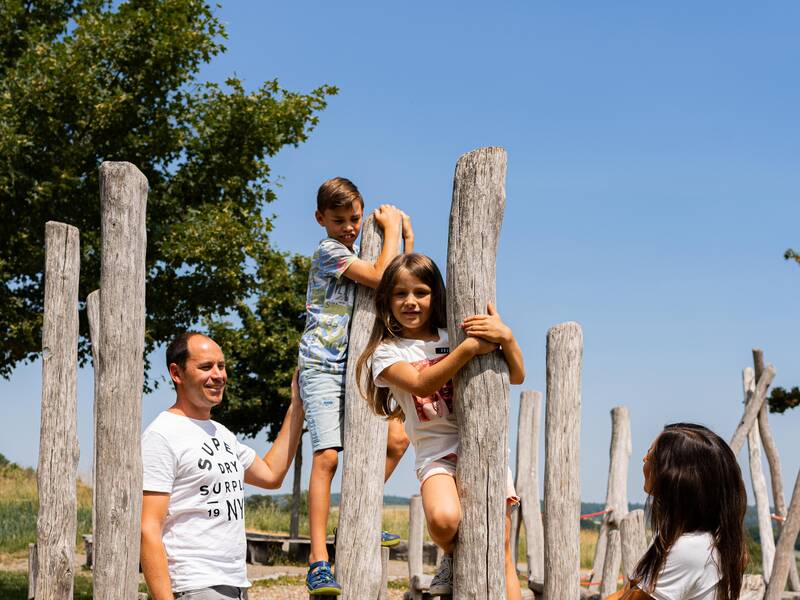 Eine Familie spielt auf einem Spielplatz.