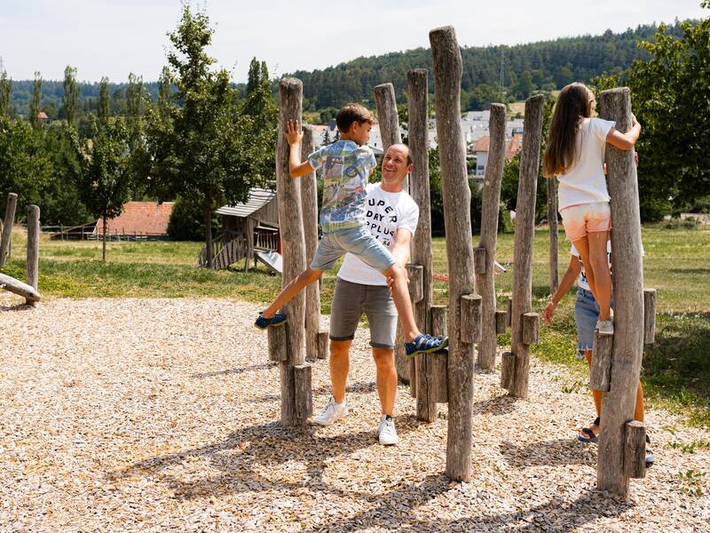 Eine Familie spielt auf einem Spielplatz.