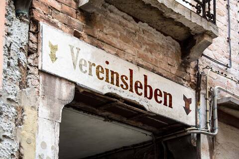 Auf einem Schild über einer Tür steht "Vereinsleben". 