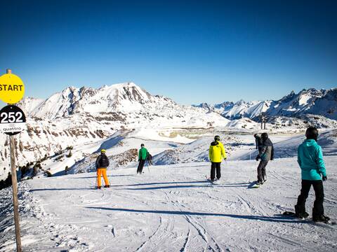 Eine Gruppe von Skifahrern auf der Piste, bei schönstem Wetter.
